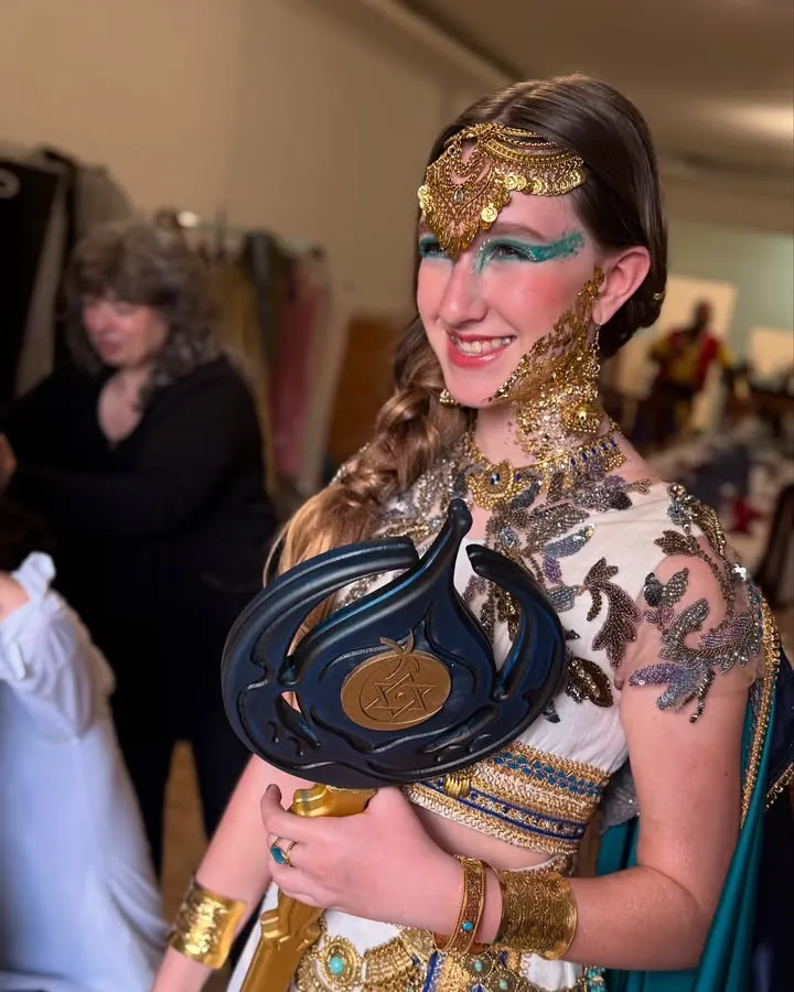 Una niña festera con tocado dorado, la mirada en turquesa y joyas sobre la mejilla