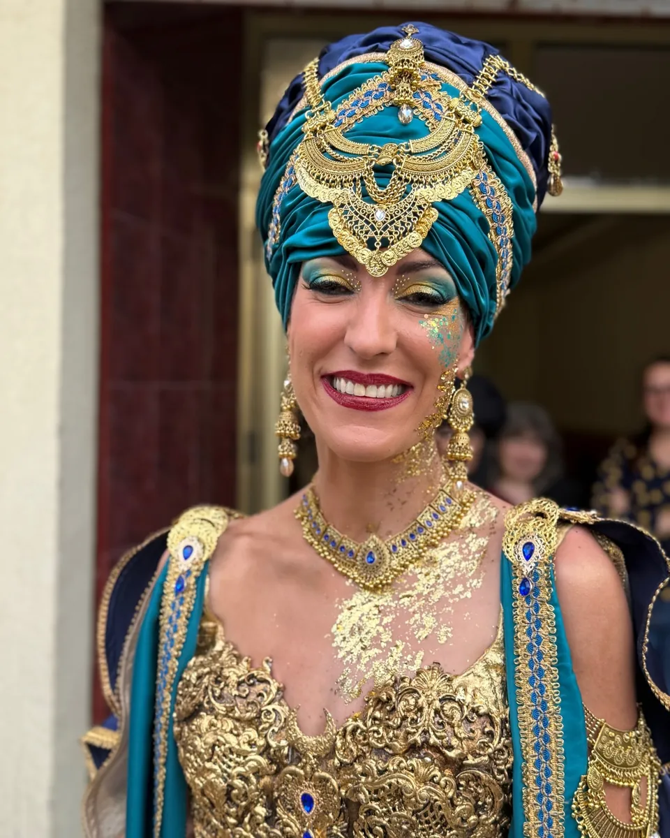 Festera con turbante turquesa y joyas doradas, la mirada en turquesa y oro y pan de oro en el cuello y el pecho
